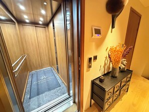 An elevator with a wooden interior and a door with a glass panel. - Luxary apartment in downtown Reykjavik (Reykjavík)