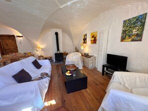 A cozy living room with a fireplace, white sofas, a television, and artwork on the walls. - Charming apartment in Vars - 6 guests (Vars)