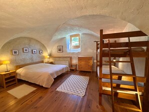 A cozy attic bedroom with a bunk bed, a small window, and wooden furniture. - Charming apartment in Vars - 6 guests (Vars)