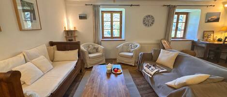 A cozy living room with a wooden coffee table, two sofas, and a chair.