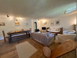 A cozy room with a bed, a sofa, a dining table set with food, and a television. - Family apartment valley view - 10 guests (Vars)