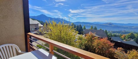 A balcony with a view of mountains and a clear sky.