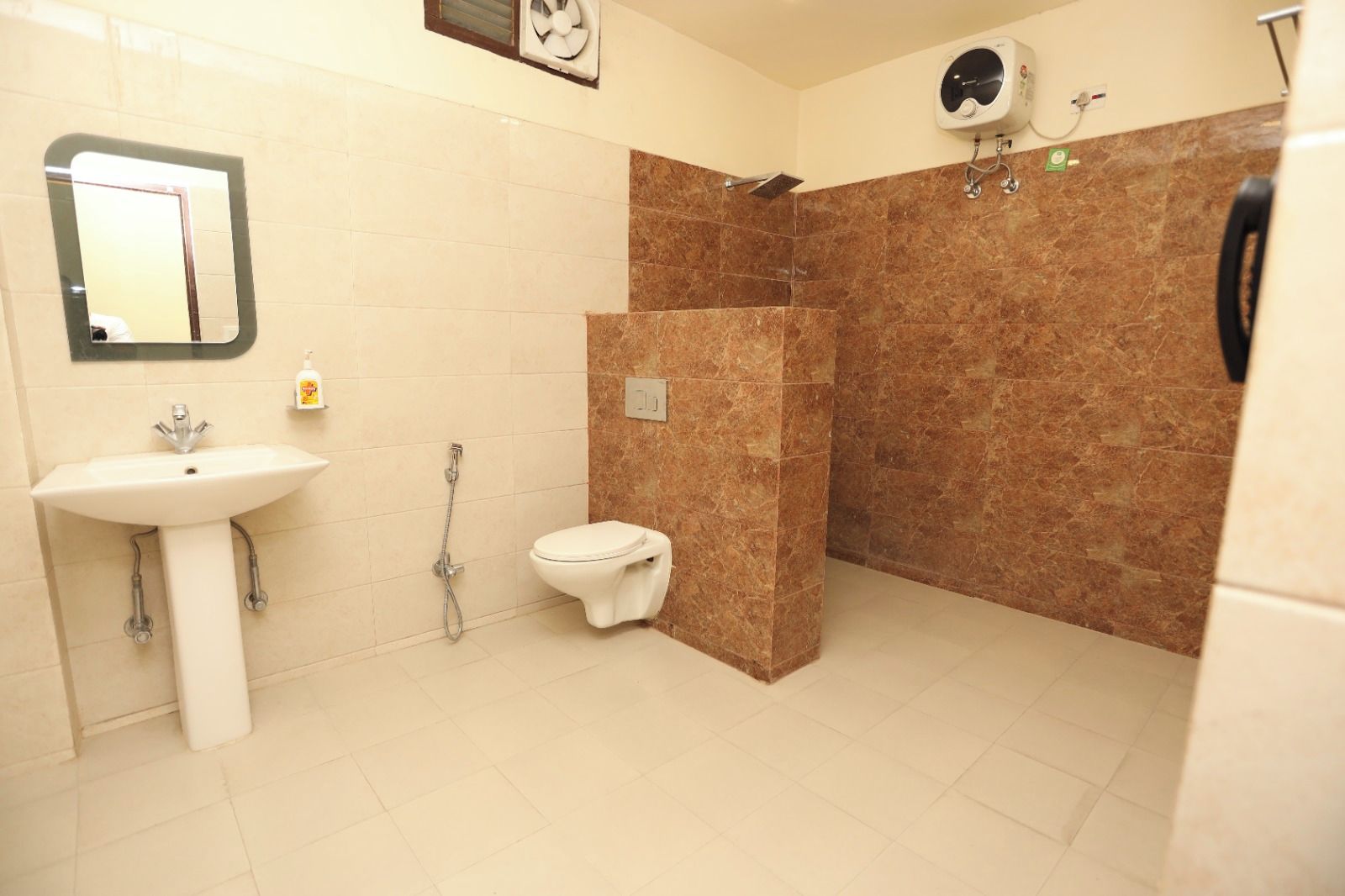 Un baño con lavamanos, inodoro y zona de ducha.