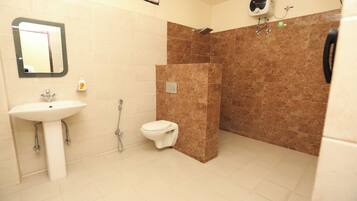 Un baño con lavamanos, inodoro y zona de ducha.