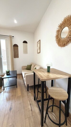 Ein modernes Wohnzimmer mit einem Holzesstisch, einer Couch und einem Couchtisch.