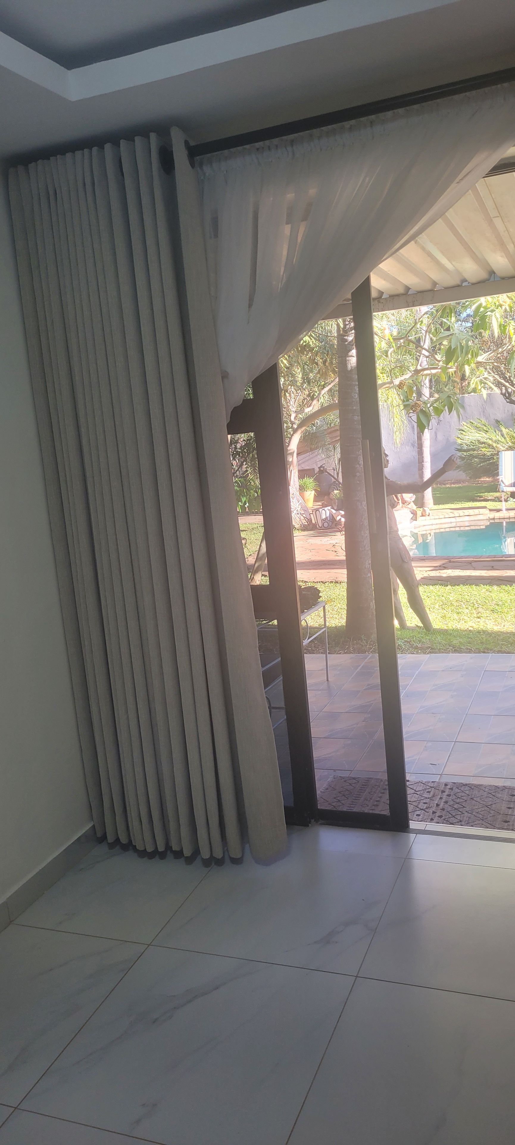 A room with a large sliding glass door leading to an outdoor area with a pool.