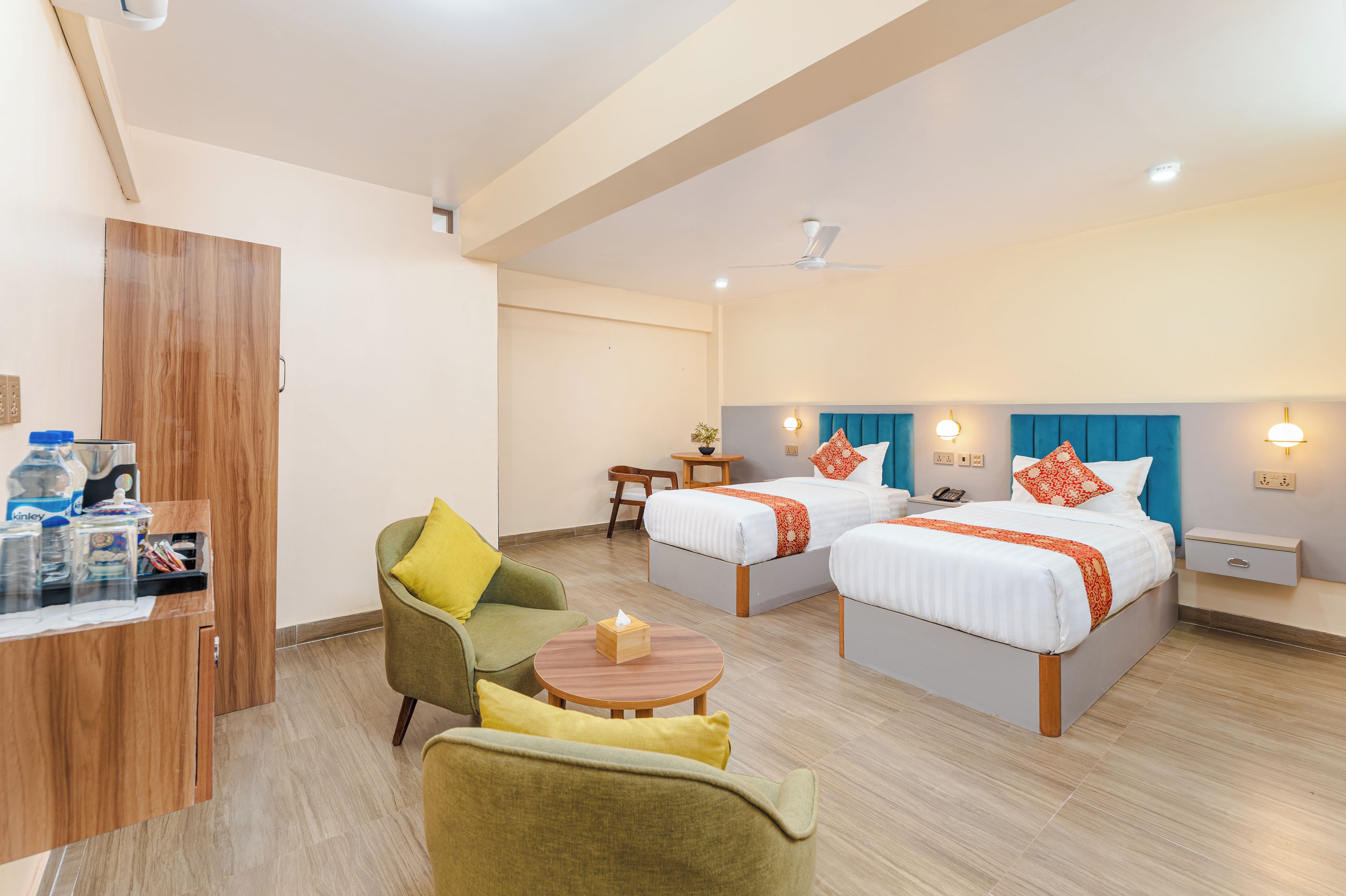 Une chambre d’hôtel avec deux lits, un bureau, une chaise et une petite table.