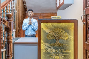 A reception desk with a sign that reads 'BOUDHA VILASA HOTEL' and a tree emblem.