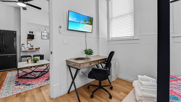 Une chambre à coucher moderne avec un lit, un bureau et un téléviseur.