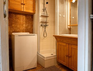 Ein kleines Badezimmer mit Dusche, Toilette und Waschbecken.