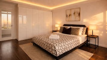 Quarto moderno com uma cama grande, duas mesas de cabeceira com luminárias, vista por uma porta e um quadro na parede.
