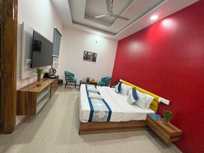 A bedroom with a bed, a TV, a desk, and a chair. - Dr Hotel Grand Plaza (Grater Noida)