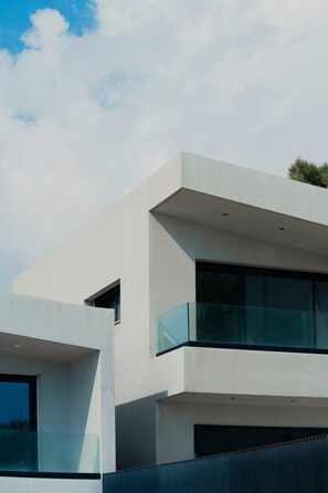 A modern building with a flat roof, large windows, and a balcony. - A Cube Villa in Keri (Zakynthos)