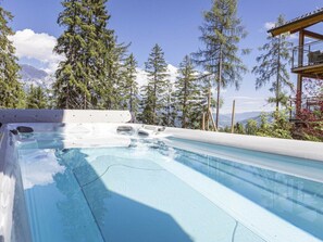 A hot tub with a clear view of surrounding trees and mountains. - Premium Chalet #13 With Sauna & Swim Spa (Schladming)