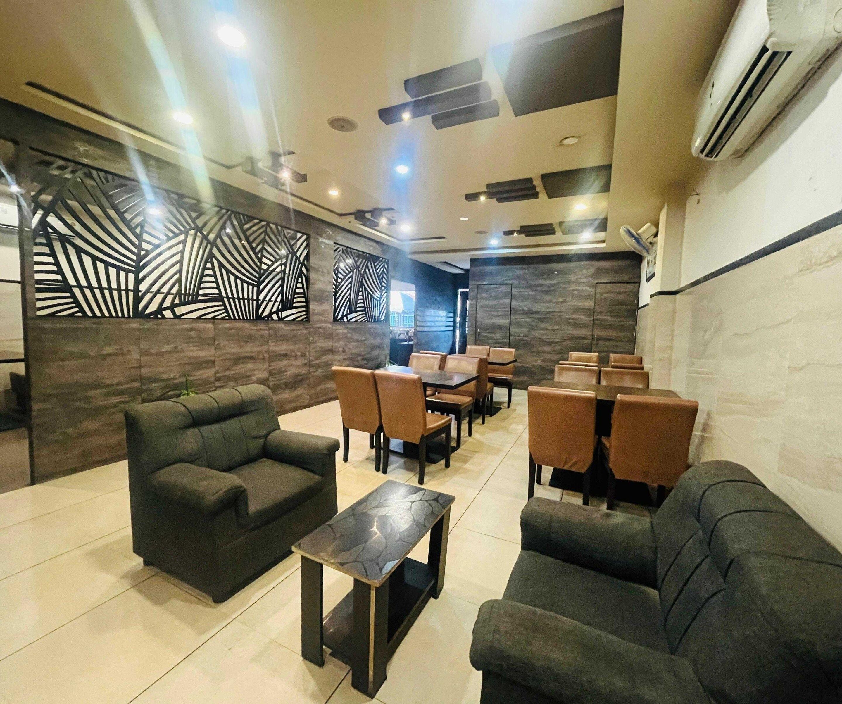A modern lounge area with sofas, tables, and a decorative wall.