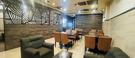 A modern lounge area with sofas, tables, and a decorative wall.