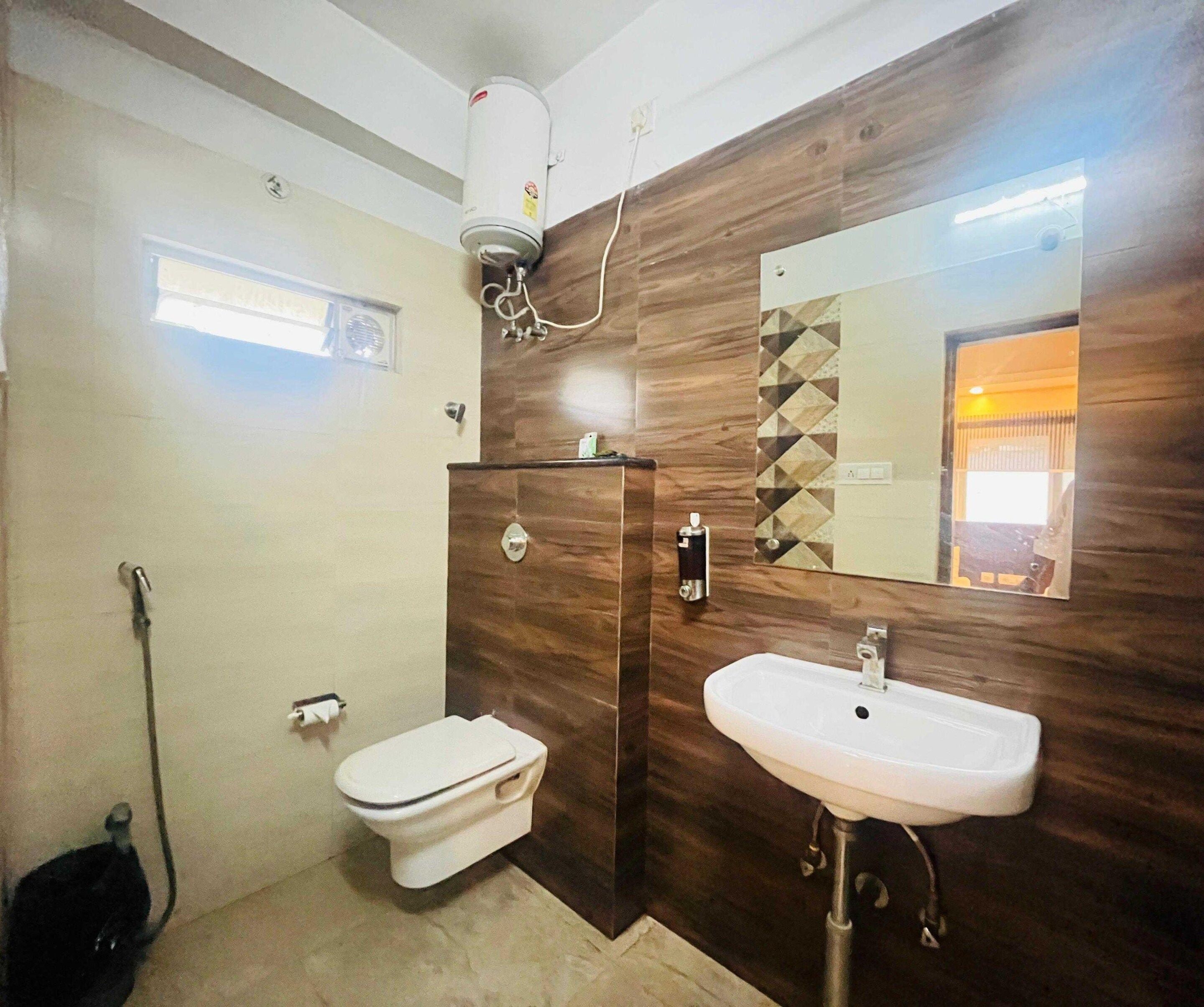 A bathroom with a toilet, a sink, a mirror, and a shower.