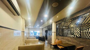 Un interior de restaurante con cabinas, una mesa de comedor y una pared decorativa.