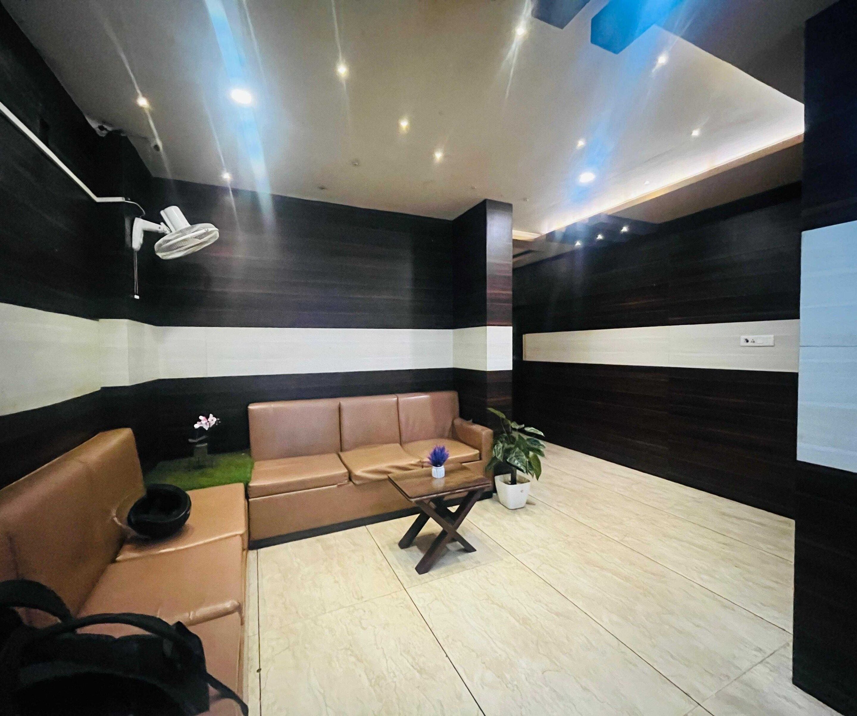 A modern waiting area with a sofa, a small table, and a potted plant.