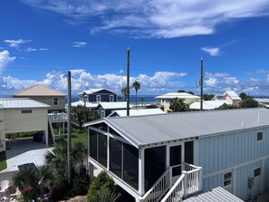 A residential area with multiple houses, a clear sky, and a view of the ocean. - Luxury Gulf-View Home with Private Pool (Mexico Beach)