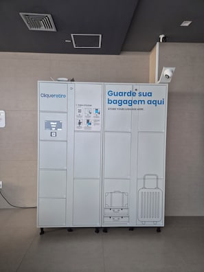 A luggage storage unit with a digital interface and instructions for use. - Complete Studio Apartment in Jardins | Oscar Freire (São Paulo)