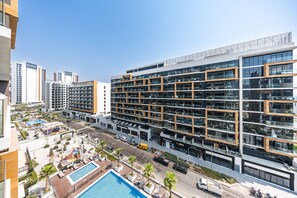 Ein modernes Mehrstöckhotel mit Dachpool, Außenbereich und Blick auf die Stadt.