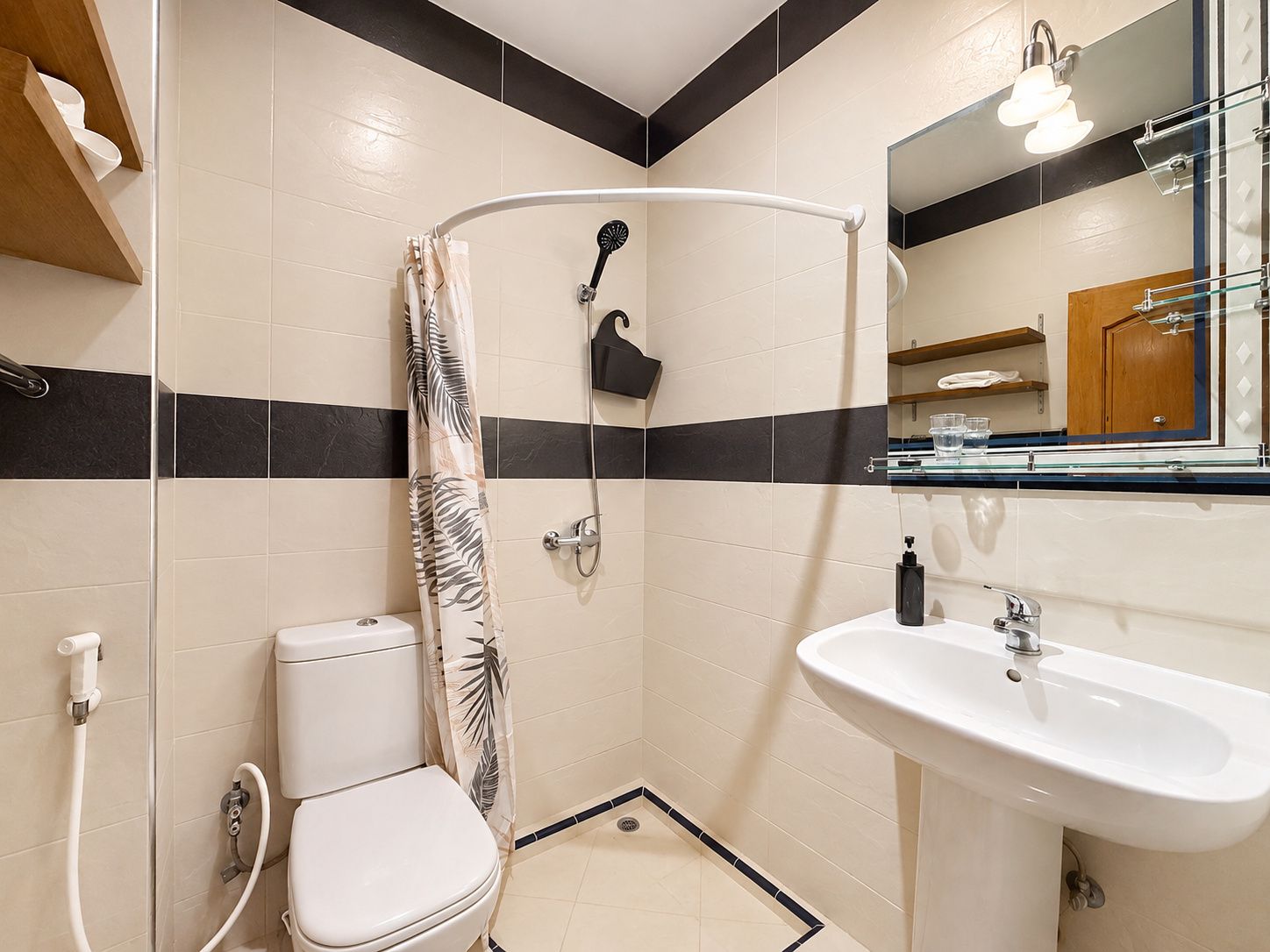 A small bathroom with a toilet, shower, and sink.