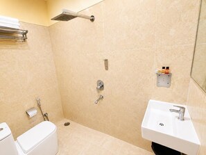 Un baño con ducha, inodoro, lavamanos y toallero.