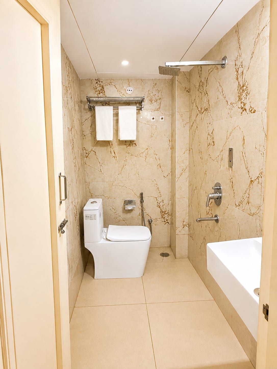 A modern bathroom with a toilet, bidet, and bathtub.