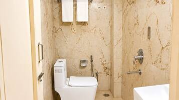 A modern bathroom with a toilet, bidet, and bathtub.