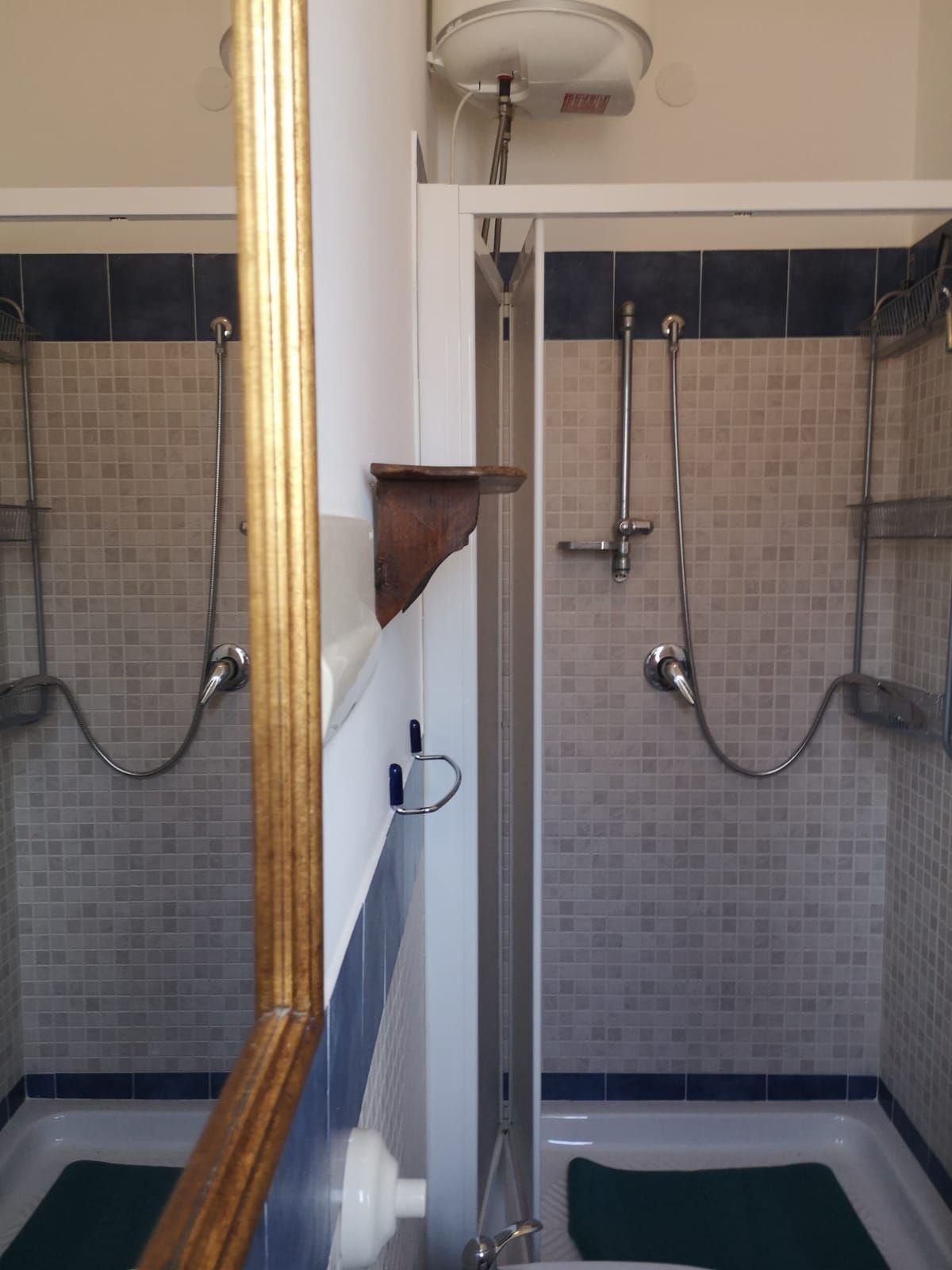 Un bagno con due cabine doccia, una vasca e un water.