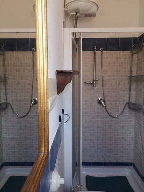 Un bagno con due cabine doccia, una vasca e un water.