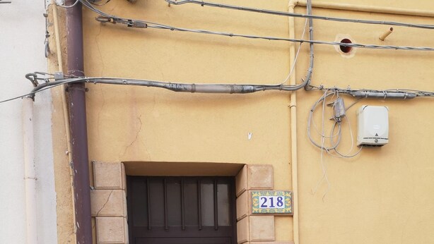 A brown door with a circular handle, a number plate '218' on the wall, and a white electrical box above. - 5 minutes from the square and the airport (Terrasini)