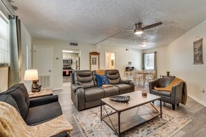 A spacious living room with a leather sofa, a coffee table, and a dining area with a table and chairs. - Cozy Updated Gatlinburg Condo Minutes to Downtown (Gatlinburg)