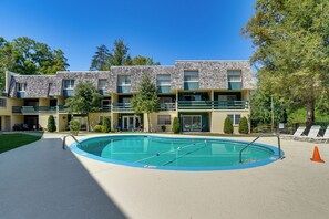 Ein Hotel mit Schwimmbad, mehreren Balkonen und einem angelegten Garten.