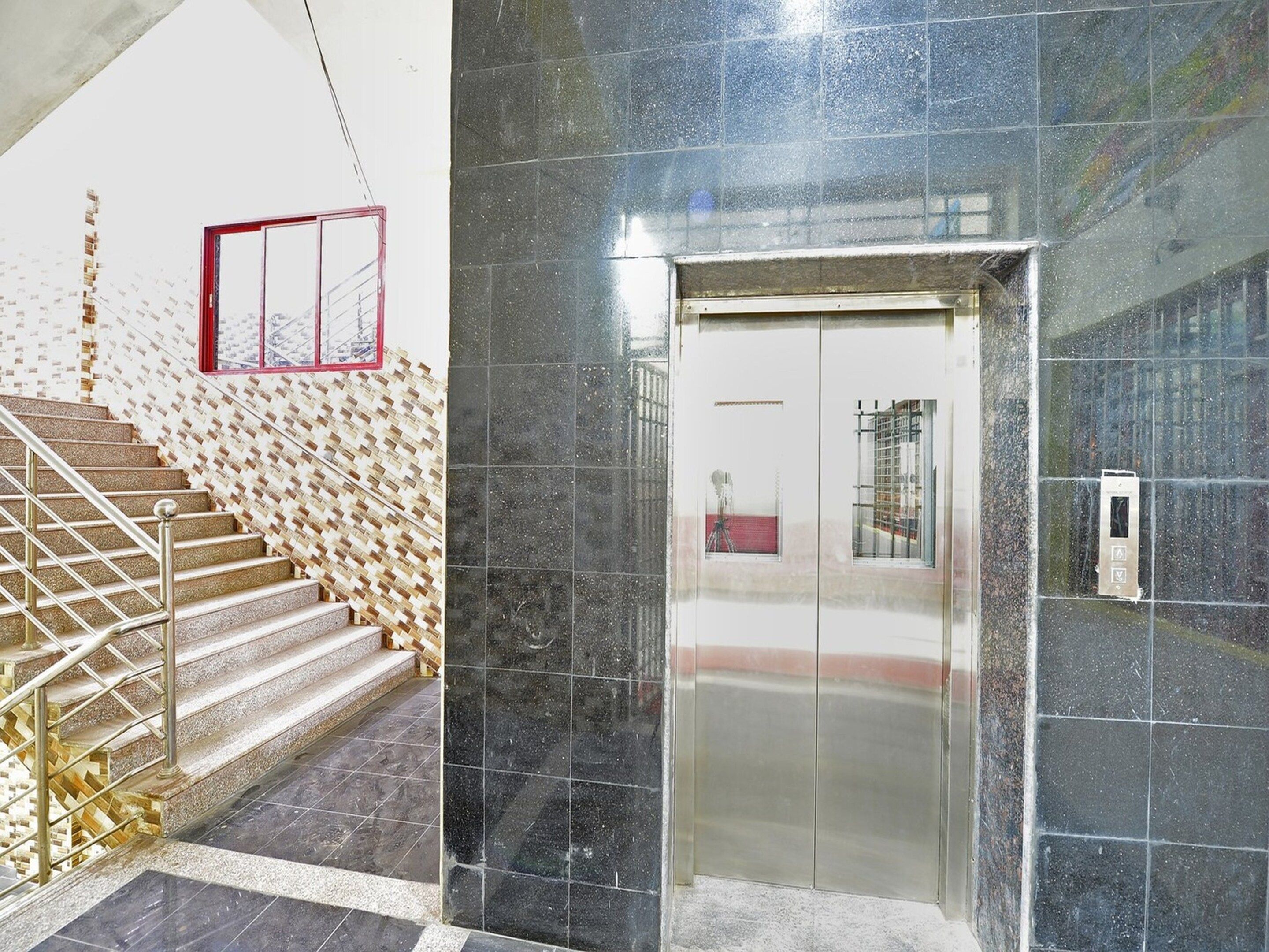 A staircase with a metal railing leading to a door with a glass panel.
