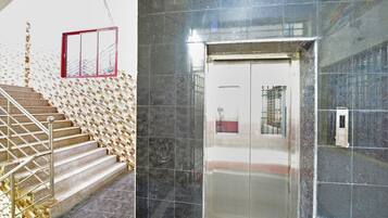 A staircase with a metal railing leading to a door with a glass panel.