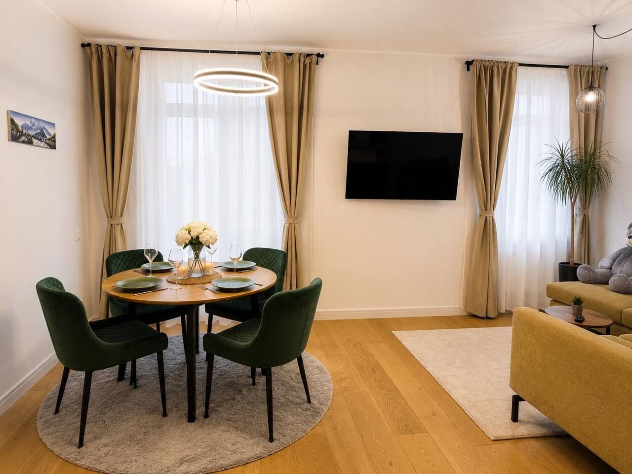 Een eethoek met een ronde tafel, vier stoelen en een bloevas.