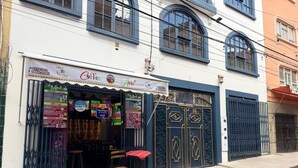 A storefront with a signboard, a metal gate, and a small stool outside. - Casona Tambo La Paz Hotel Boutique (La Paz)