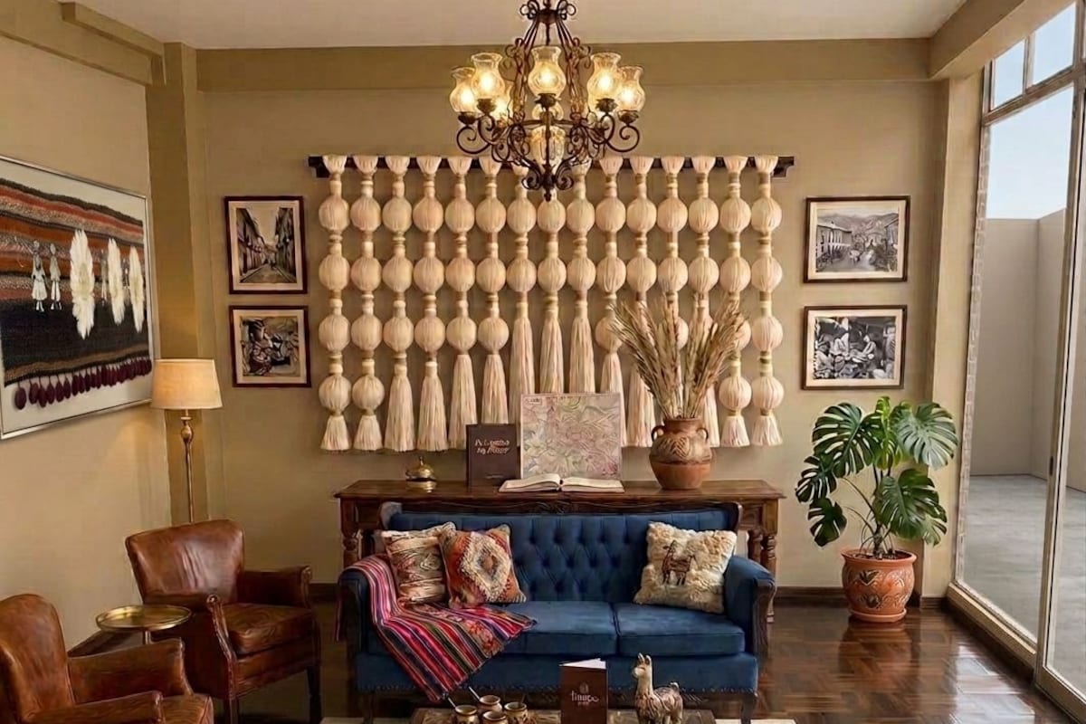 A living room with a blue sofa, leather armchairs, a wooden coffee table, and a chandelier.