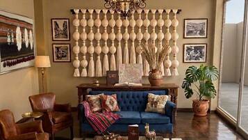 A living room with a blue sofa, leather armchairs, a coffee table, and a chandelier.