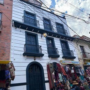 Um edifício com várias varandas e uma loja no térreo exibindo diversos artigos.