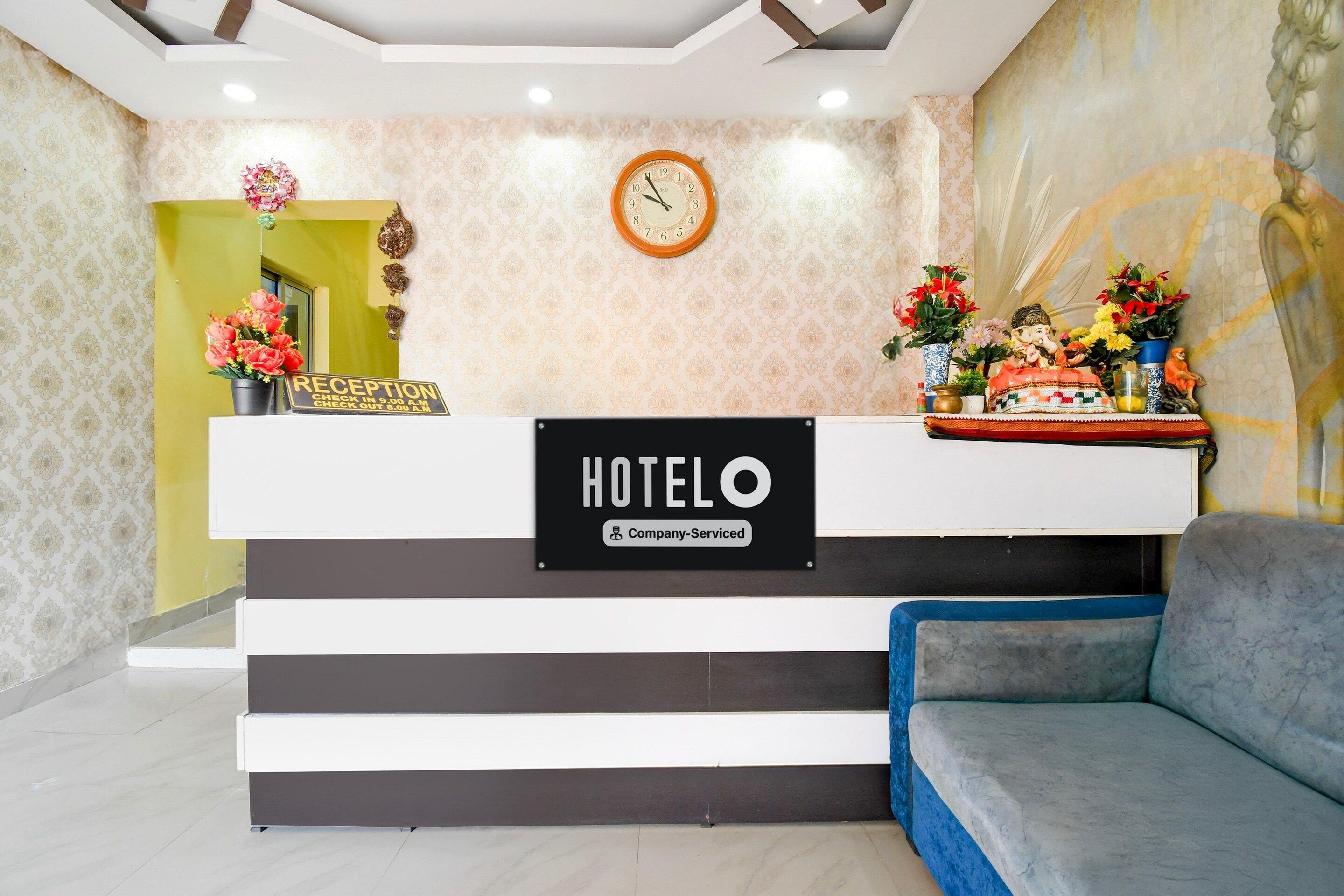 Una reception d'albergo con orologio, insegna e una statua.