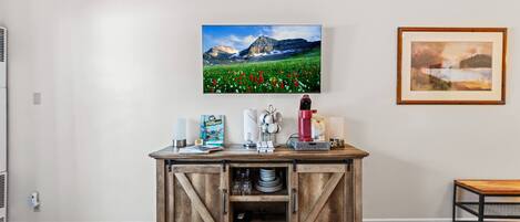 Ein Schlafzimmer mit zwei Betten, einer Holzkommode mit Schubladen, einem gerahmten Bild an der Wand und einem Gemälde.