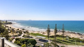 Blick auf die Küste mit Strand, Parkplatz und blauem Himmel.