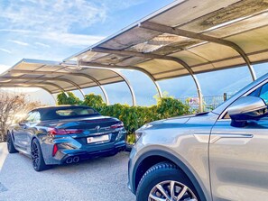 Two parked cars under a covered parking structure with a mountainous backdrop. - Beautiful private villa for 6 guests with A/C, WIFI, TV and patio (Ranzo)