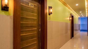A hotel corridor with a wooden door marked '304', a light fixture, and a tiled floor.