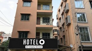 Un edificio de hotel con varios pisos, balcones y un letrero que indica que es un hotel de servicios corporativos.