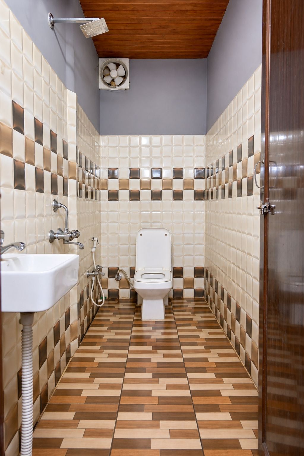 A bathroom with a toilet, sink, shower, and tiled walls.