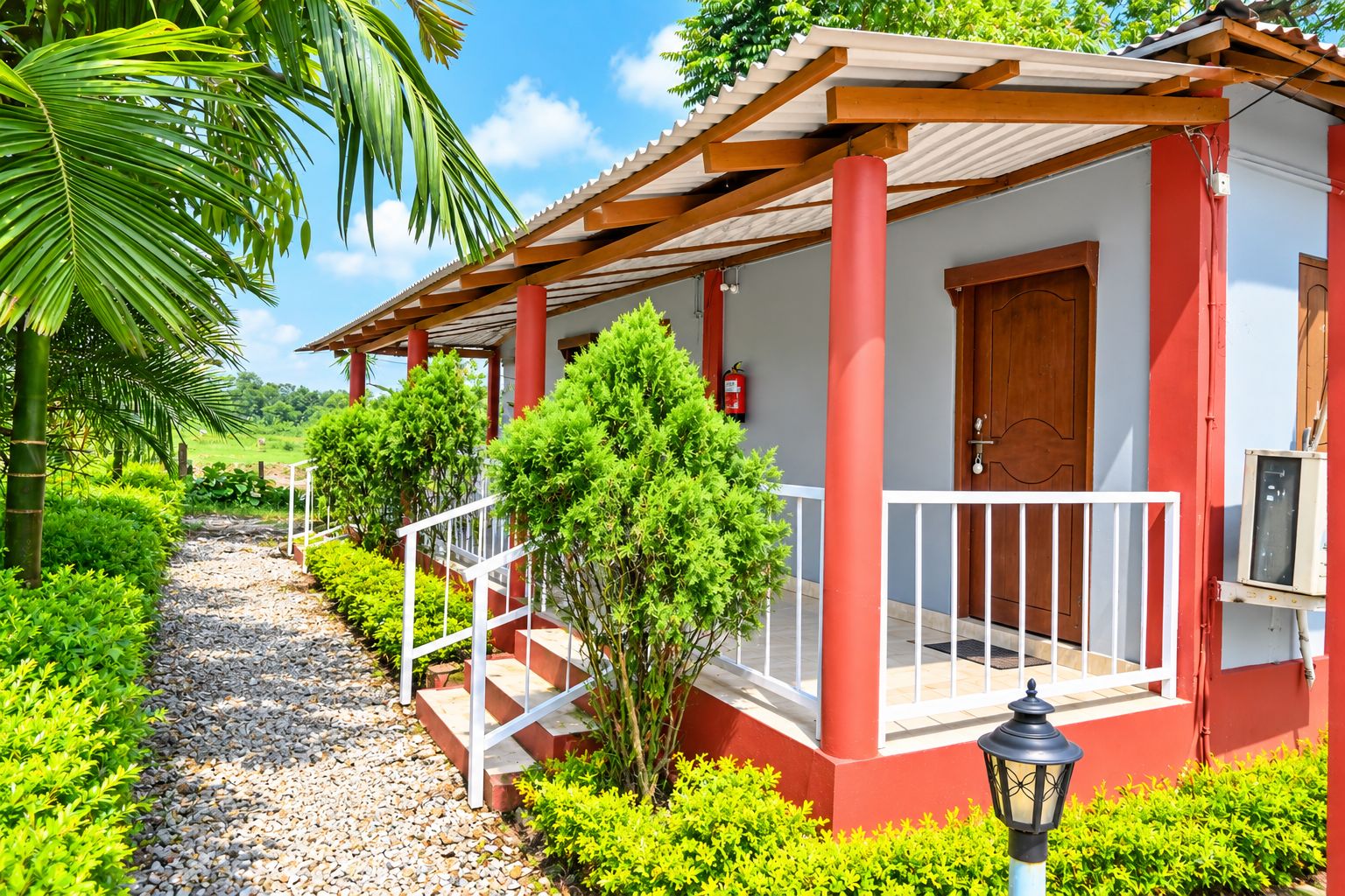 A red building with a porch, steps, and a door.